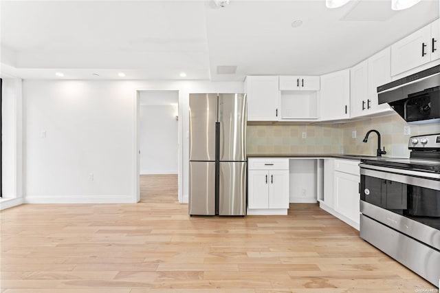 kitchen with white cabinets, appliances with stainless steel finishes, light hardwood / wood-style flooring, and sink