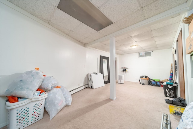 basement featuring baseboard heating, carpet flooring, and a drop ceiling