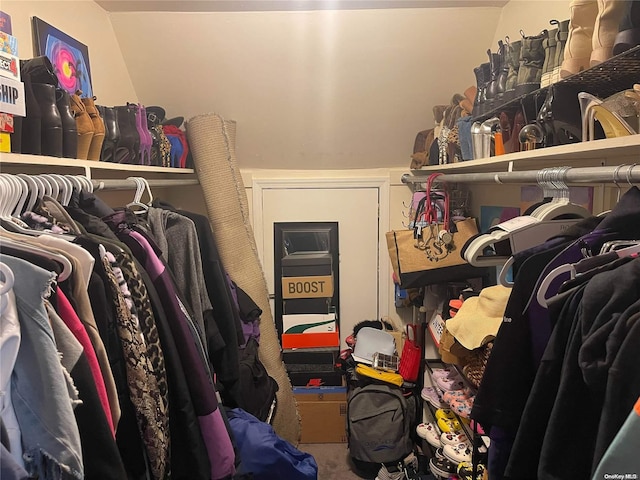 spacious closet featuring carpet flooring and vaulted ceiling