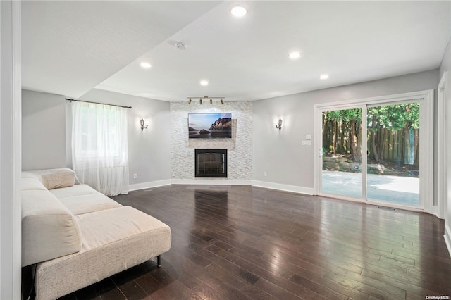 living room featuring a healthy amount of sunlight, dark hardwood / wood-style flooring, and a fireplace