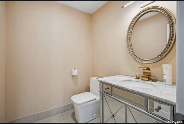 bathroom featuring tile patterned flooring, vanity, and toilet