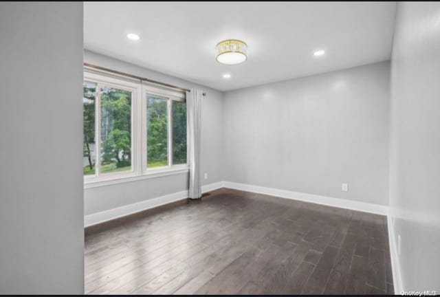 spare room featuring dark wood-type flooring