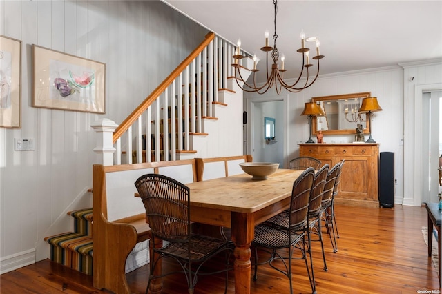 dining area featuring hardwood / wood-style flooring, ornamental molding, and a chandelier