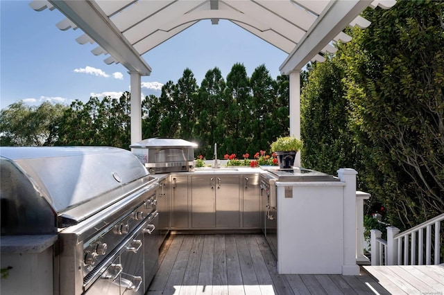 deck featuring exterior kitchen, sink, and grilling area