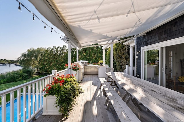 wooden deck featuring a water view and ceiling fan