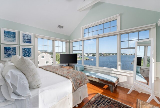 bedroom with hardwood / wood-style flooring, high vaulted ceiling, and multiple windows