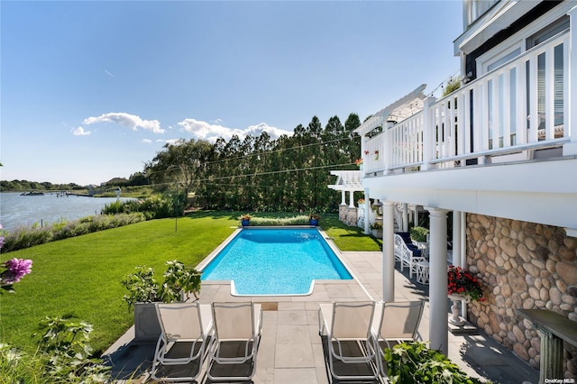 view of pool featuring a water view, a patio area, and a lawn