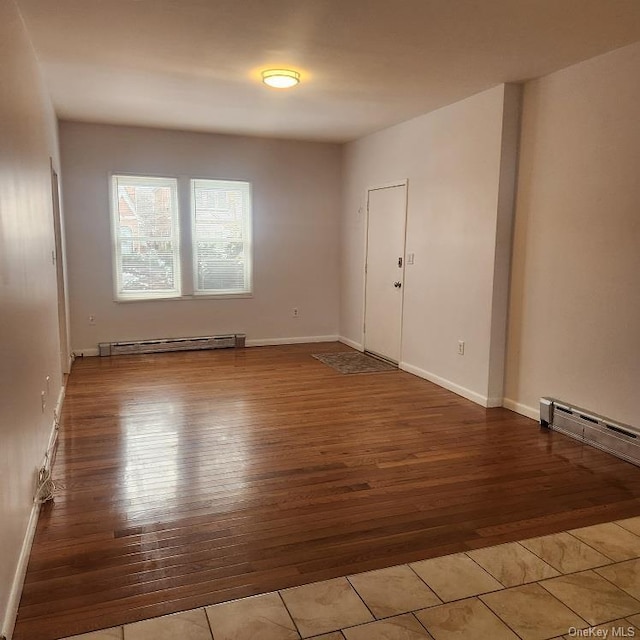 unfurnished room featuring a baseboard radiator and light hardwood / wood-style flooring