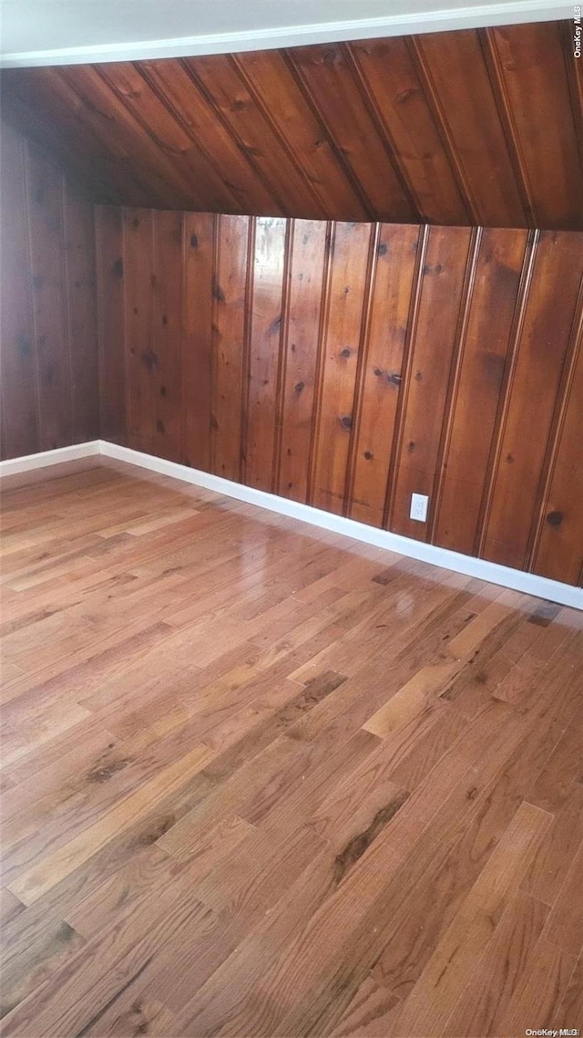 interior space with light hardwood / wood-style floors, wooden ceiling, wooden walls, and vaulted ceiling