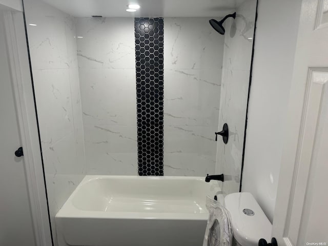 bathroom with toilet and tiled shower / bath