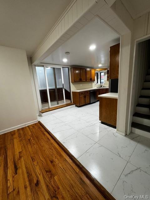 kitchen with dishwasher, sink, light hardwood / wood-style floors, and kitchen peninsula