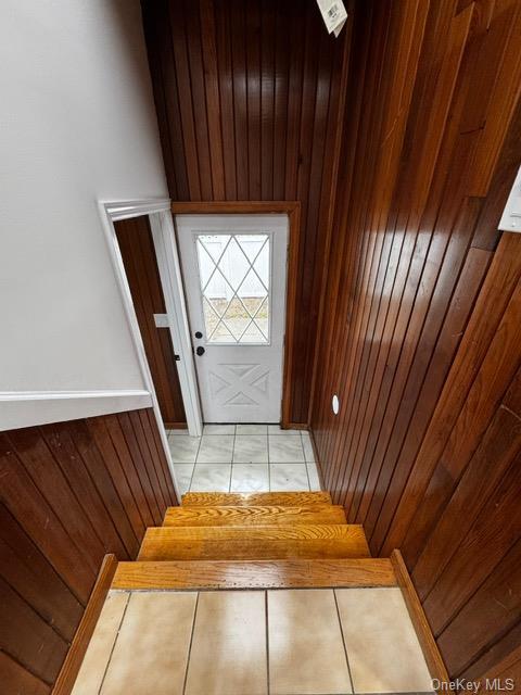 doorway to outside featuring wooden walls