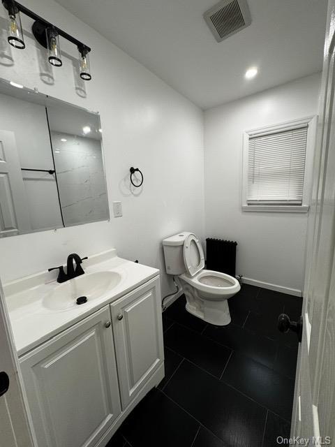 bathroom featuring vanity, toilet, and tile patterned flooring