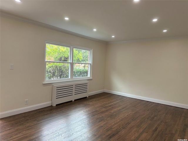 spare room featuring radiator heating unit, dark wood-type flooring, and ornamental molding