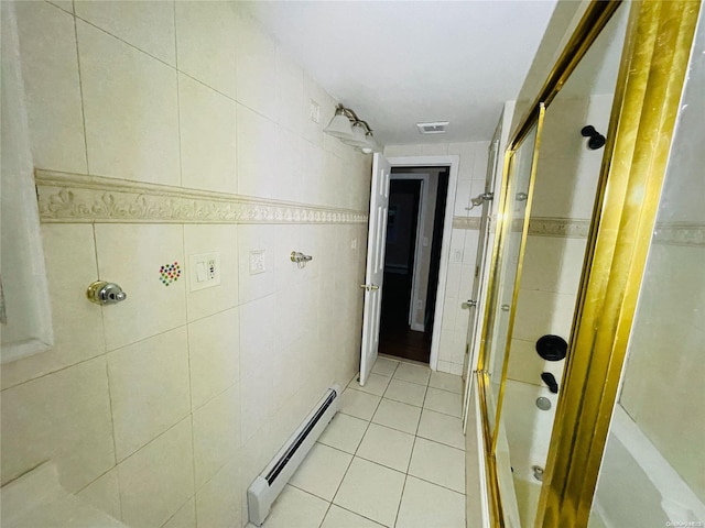 bathroom featuring tile patterned flooring, tile walls, a baseboard heating unit, and enclosed tub / shower combo