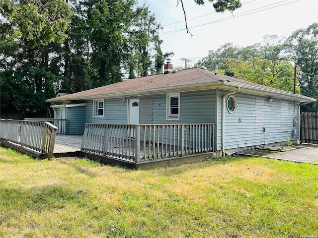 back of house featuring a deck and a lawn