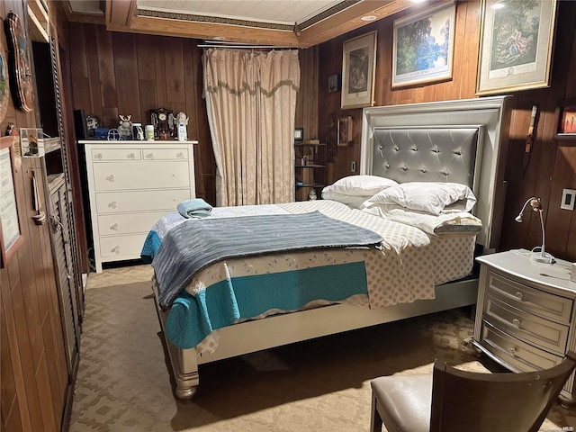 bedroom featuring light carpet and wooden walls