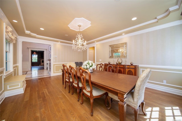 dining area featuring a chandelier, light hardwood / wood-style flooring, and crown molding