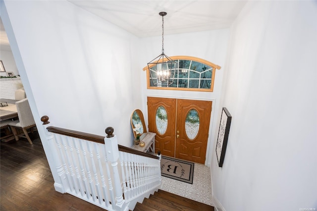 entryway with dark hardwood / wood-style flooring and a notable chandelier