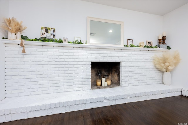 interior details featuring hardwood / wood-style flooring and a brick fireplace