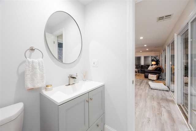 bathroom featuring hardwood / wood-style flooring, vanity, and toilet