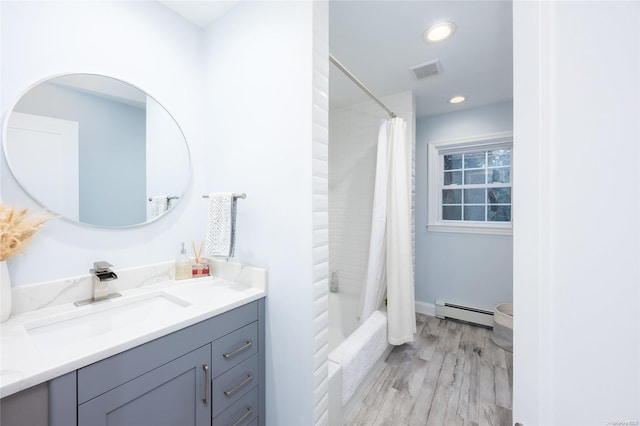 bathroom with baseboard heating, shower / bath combo with shower curtain, hardwood / wood-style floors, and vanity