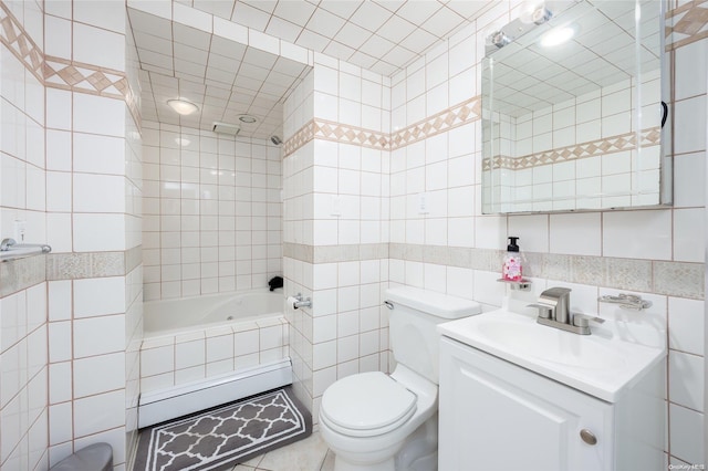 full bathroom featuring vanity, tiled shower / bath combo, toilet, and tile walls