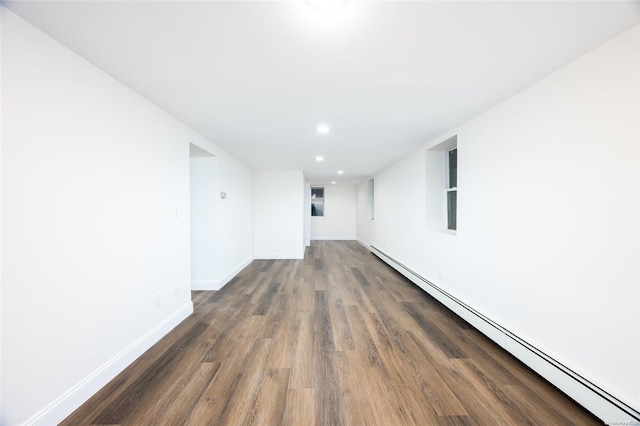 unfurnished room with dark hardwood / wood-style floors and a baseboard radiator