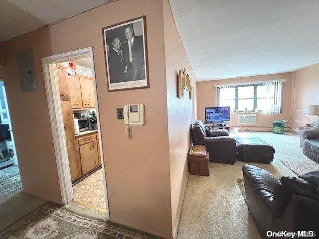 hallway featuring light carpet and electric panel