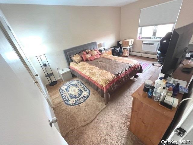 carpeted bedroom with cooling unit and a baseboard radiator