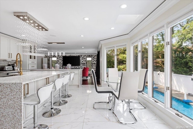 interior space featuring crown molding, sink, and a chandelier