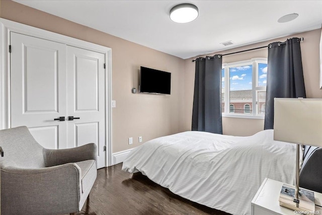 bedroom with dark wood-type flooring and a closet