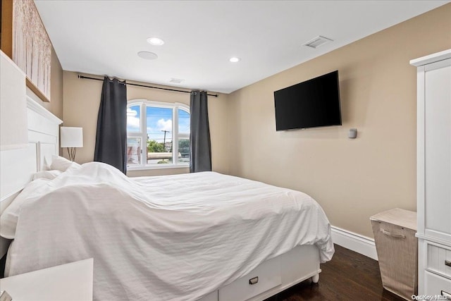 bedroom with dark hardwood / wood-style floors