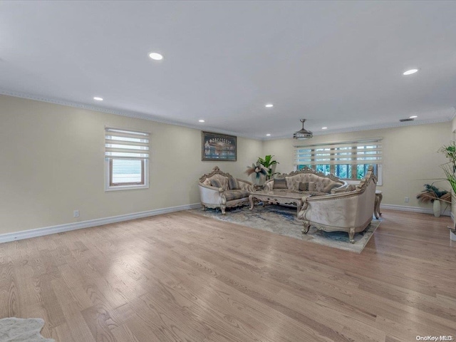 living room with light hardwood / wood-style flooring and crown molding