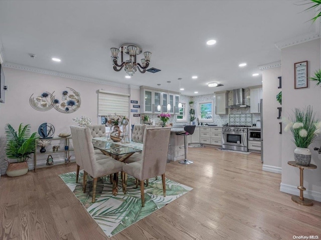 dining area featuring light hardwood / wood-style flooring and crown molding