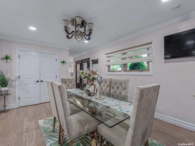 dining room featuring light hardwood / wood-style floors and crown molding