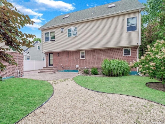 back of property featuring a patio area and a lawn