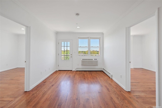 interior space featuring a wall mounted AC, crown molding, wood-type flooring, and a baseboard radiator