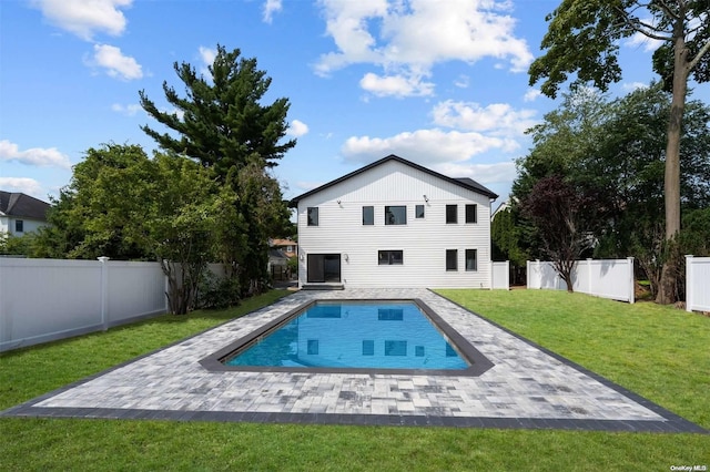 rear view of house featuring a fenced in pool, a patio area, and a yard