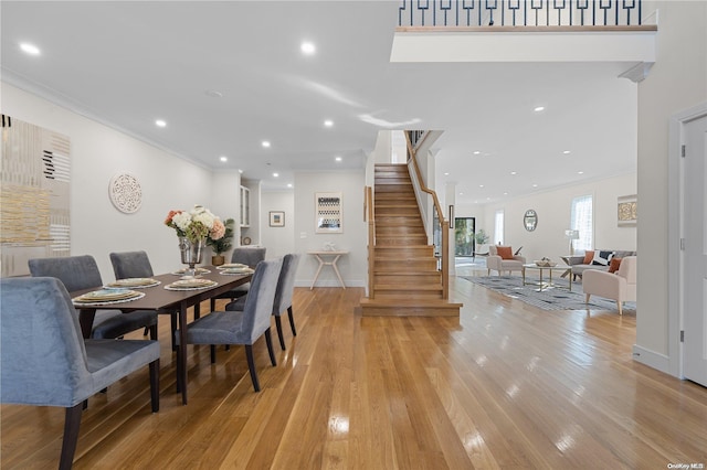 dining space featuring light wood-type flooring and crown molding