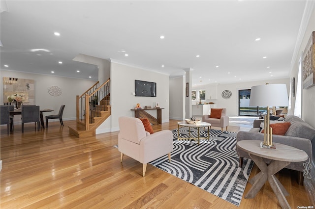 living room featuring light wood-type flooring, ornamental molding, and a wealth of natural light