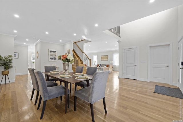 dining space featuring light wood-type flooring and crown molding