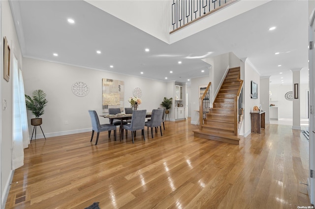 dining area with light hardwood / wood-style flooring and ornamental molding