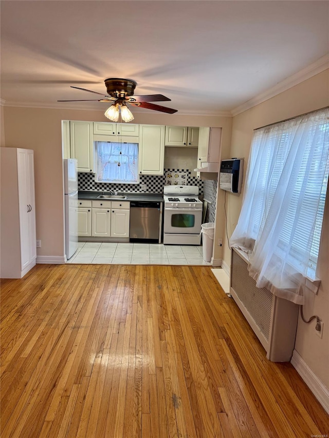 kitchen with light hardwood / wood-style flooring, stainless steel dishwasher, white fridge, range with gas stovetop, and decorative backsplash