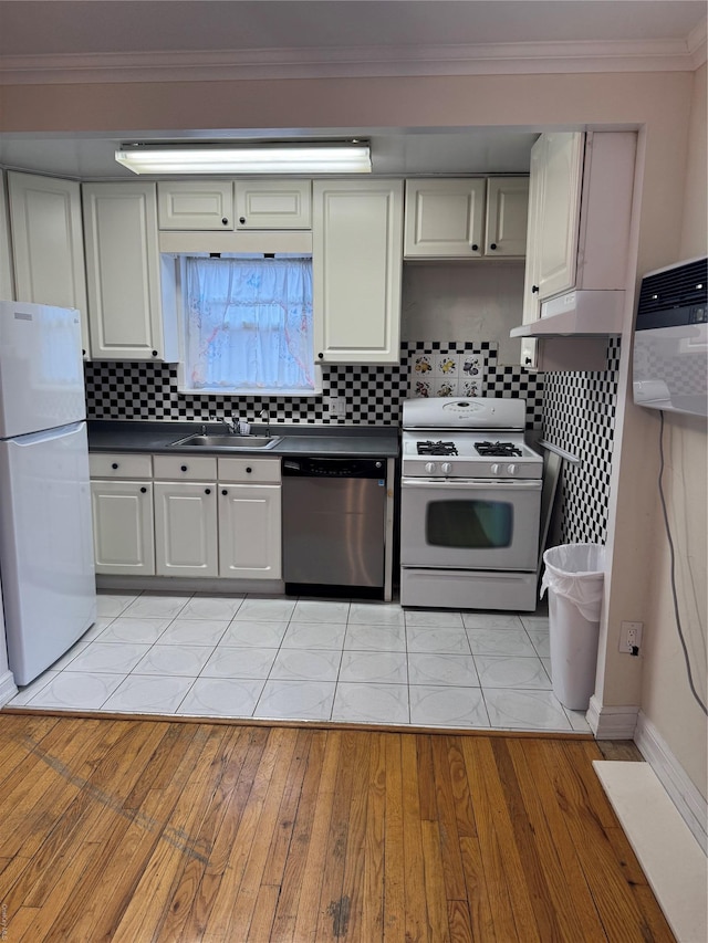 kitchen featuring white appliances, light hardwood / wood-style floors, tasteful backsplash, and crown molding