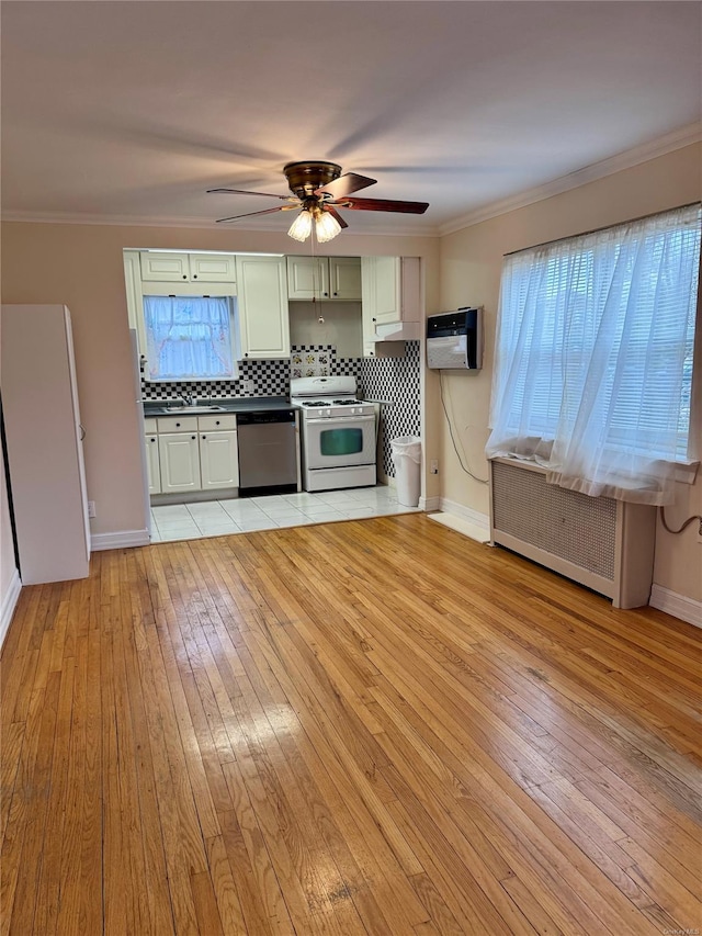 kitchen featuring light wood-type flooring, backsplash, stainless steel dishwasher, radiator, and white range with gas cooktop