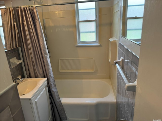 bathroom featuring shower / tub combo, vanity, and tile walls