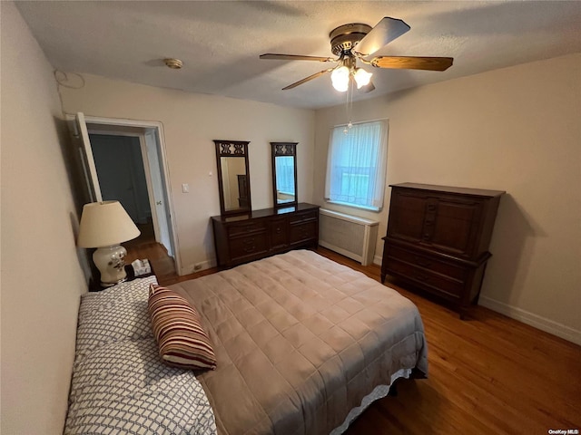 bedroom featuring wood-type flooring, a textured ceiling, and ceiling fan