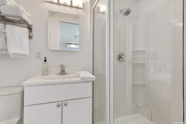 bathroom featuring vanity, toilet, and a shower with shower door