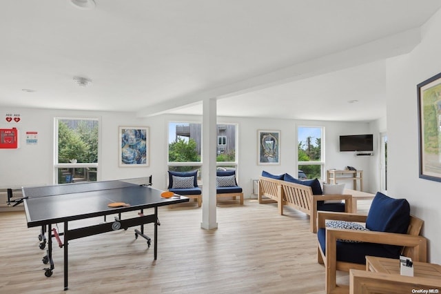 game room with beam ceiling, light hardwood / wood-style flooring, and a healthy amount of sunlight